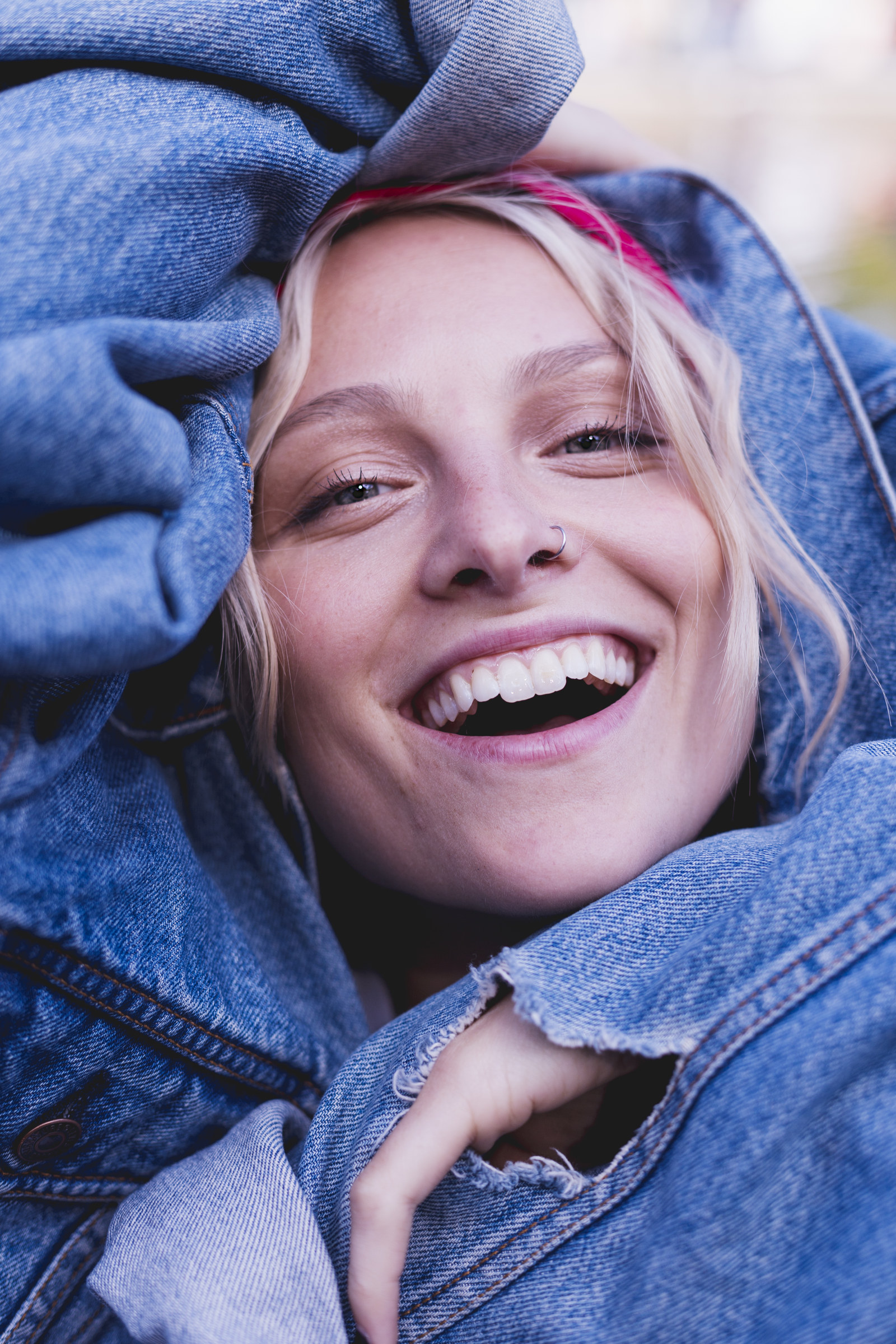 Emily Brimlow laughing in a denim jacket